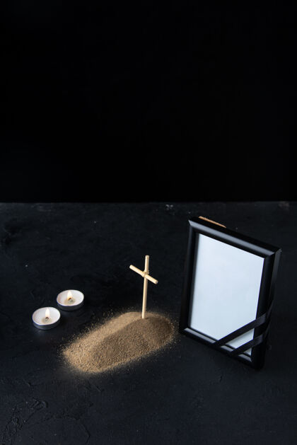 黑暗带十字架和相框的小坟墓的正面图 在黑暗中空白相框空相框