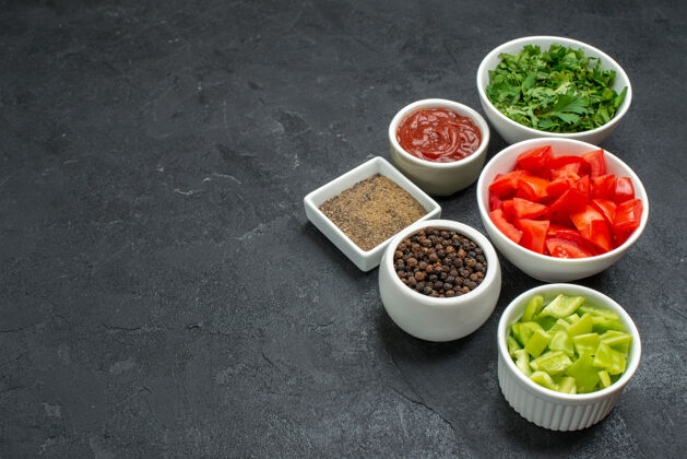 绿色正面图新鲜的红色西红柿蔬菜片和绿色蔬菜放在深色的桌子上成熟的沙拉健康餐胡椒食物切片