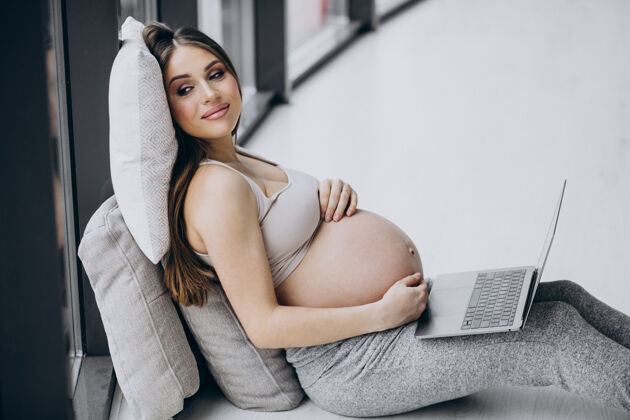 母亲女人在家用电脑怀孕孕妇人