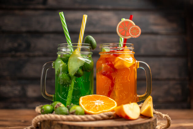 新鲜在木制的砧板上 可以看到新鲜美味的果汁和苹果和橙子鸡尾酒玻璃杯水果