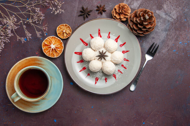 餐俯瞰美味的椰子糖小而圆 用茶杯在深色背景上形成椰子糖茶甜饼饼干视图曲奇糖果
