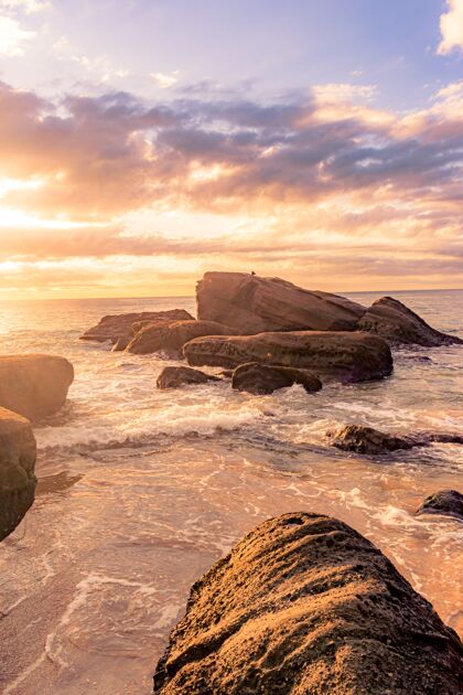 日落美丽的夕阳下岩石海滩的迷人景色海岸海滩光