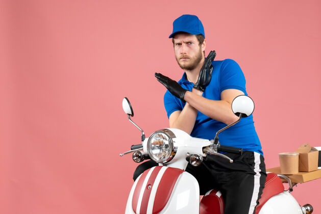 蓝色正面图身着蓝色制服的男快递员骑着粉色快餐服务的彩色自行车送货工作制服服务正面