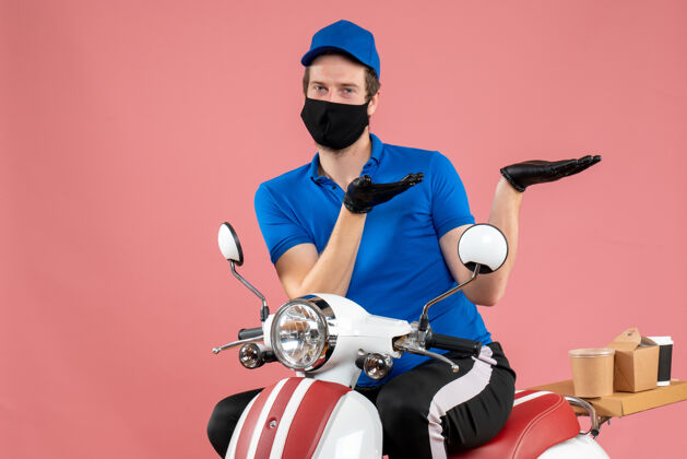 自行车正面图身穿蓝色制服 戴着粉色口罩的男性快递员服务病毒自行车快餐店-工作面具服务摩托车