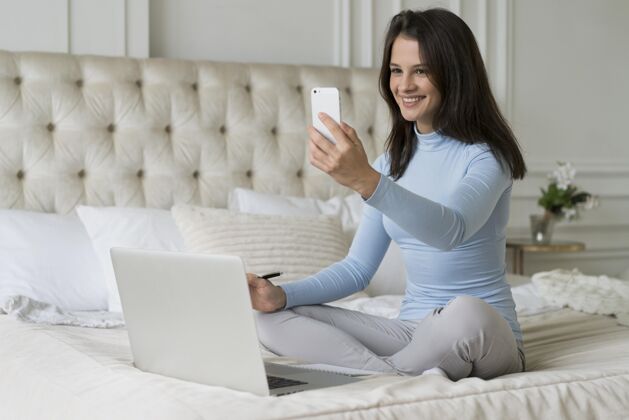 虚拟工作时躺在床上的女人房子设备网络