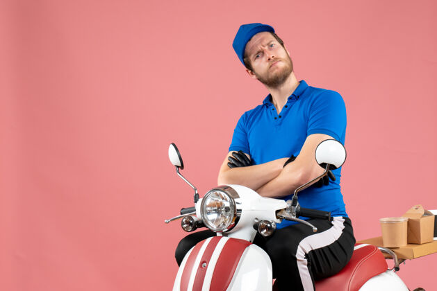 自行车正面图身着蓝色制服的男快递员骑着粉色食品自行车送货工作快餐工作制服人工作