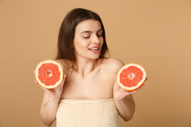 果汁近景半裸体女人完美的皮肤裸妆举行葡萄柚隔离米色粉彩墙上适用治疗成熟