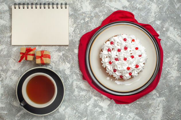 食物上图：红色布料上装饰着水果的美味奶油蛋糕小杯子早餐