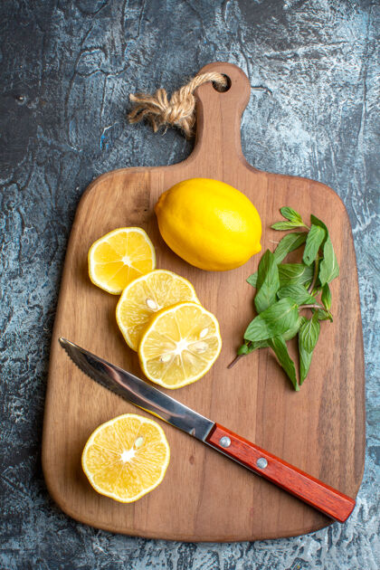刀上图：新鲜柠檬和薄荷刀放在木制砧板上柑橘柠檬薄荷