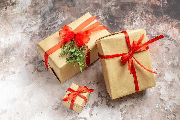 圣诞节前视图可爱的圣诞礼物与红色蝴蝶结绑在灯光背景礼物蝴蝶结盒子