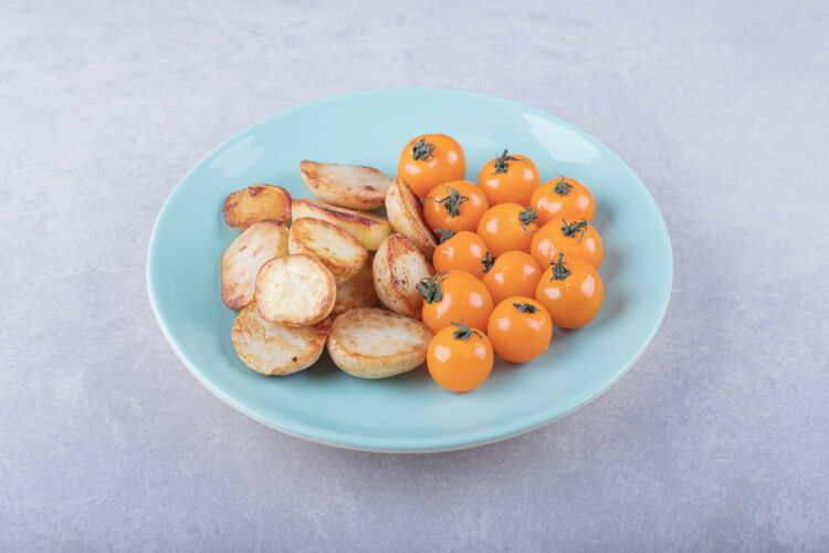 晚餐蓝色盘子上的炸土豆和西红柿薯条脆美味