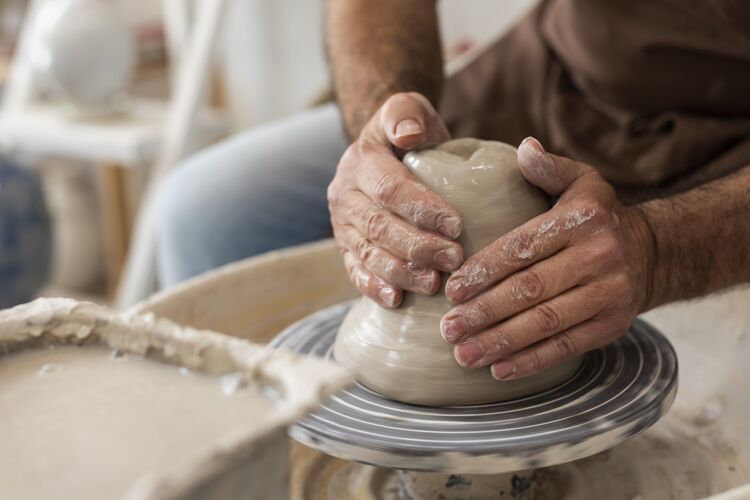 艺术家闭上双手在室内做陶器创作室内手工