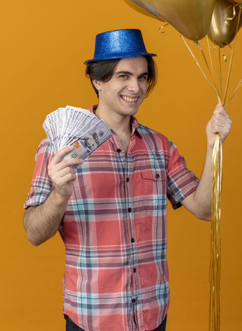 复制面带微笑的白人帅哥 头戴蓝色派对帽 手里拿着氦气球和钱男人帽子橙色