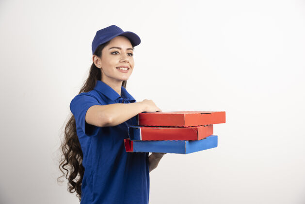 服务身着蓝色制服的快乐微笑送货女孩 白色背景上有外卖披萨盒高质量照片食品送货职业