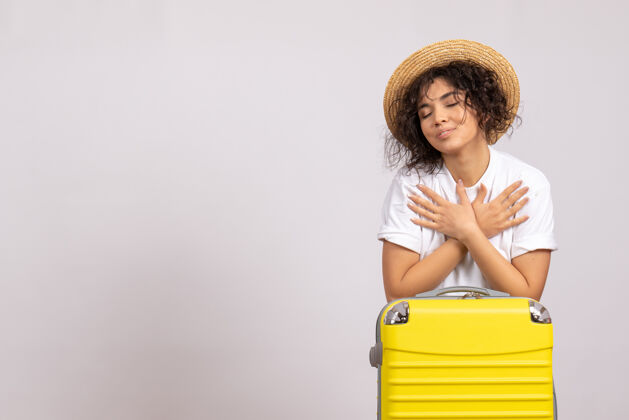 成人正面图年轻女性带着黄色的袋子准备白色背景色的飞行旅行飞机旅游度假微笑年轻女性人