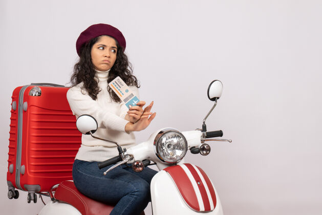 持有正面图骑自行车的年轻女性手持车票在白色背景色的速度城市车辆摩托车度假飞行道路车票道路年轻女性
