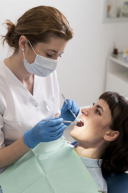 垂直在牙医那里做手术的女病人妇女专业从业者