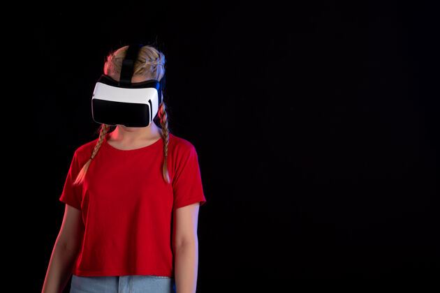 游戏年轻女性在黑暗的墙上玩虚拟现实的前视图肖像黑色黑色