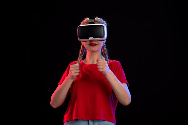 肖像年轻女性在黑暗的墙上玩虚拟现实的前视图虚拟现实游戏正面