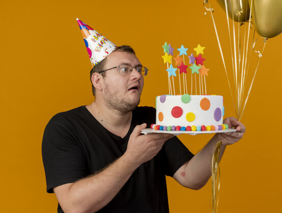 斯拉夫兴奋的成年斯拉夫人戴着眼镜 戴着生日帽 手里拿着氦气球和生日蛋糕橙色光学眼镜