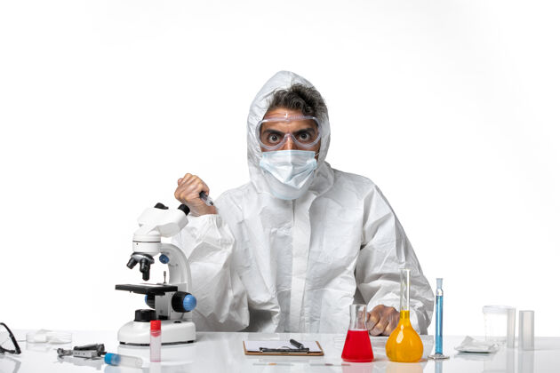 口罩男医生穿着防护服 带着无菌口罩 在白墙上拿着针剂医学健康大流行