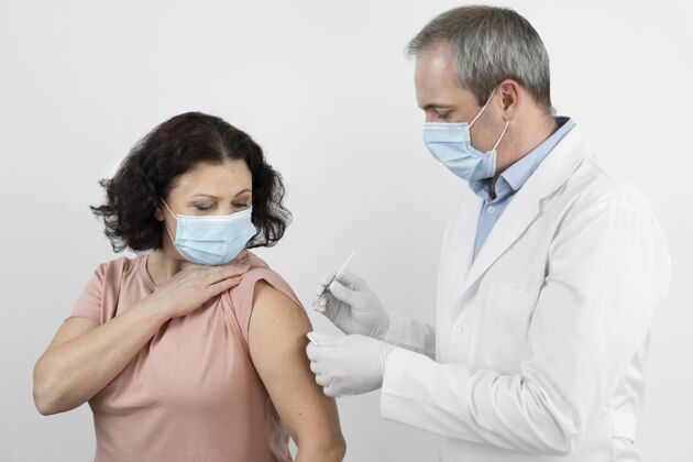 女人女病人在接种疫苗疫苗注射面罩预防