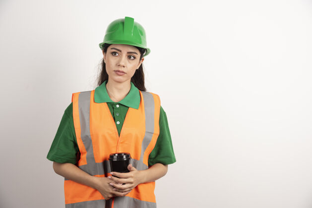 女人年轻的女建造师拿着黑色的杯子望着别处高质量的照片建筑师开发专业