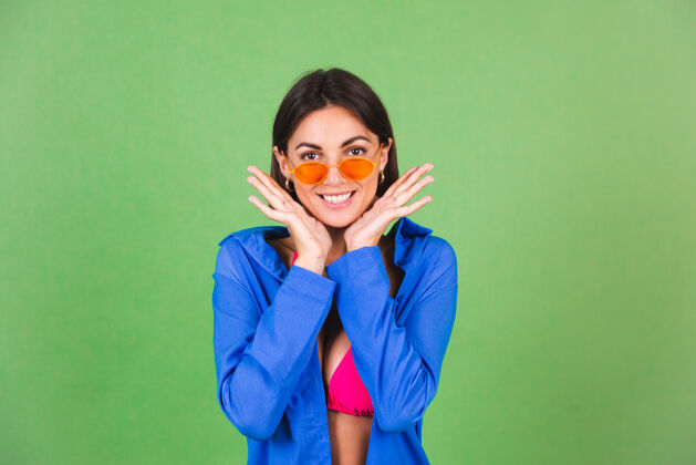 相机夏日修身运动型女士 粉色比基尼 蓝色衬衫 橙色墨镜 绿色 快乐积极女性曲线年轻