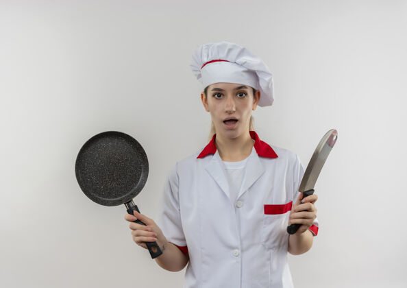 切肉刀年轻漂亮的厨师穿着厨师制服 手拿煎锅和切肉刀 隔着白色的墙壁烹饪年轻制服