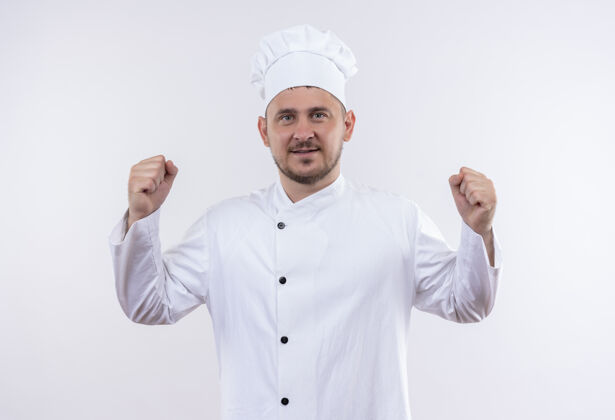 姿态自信的年轻帅哥厨师身着厨师制服 在白色的墙壁上做着坚强孤立的手势厨师自信烹饪