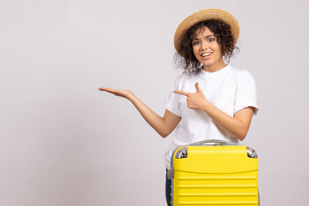 年轻女性正面图年轻女性 带着黄色的包 准备乘坐白色背景航班旅行 休息航行 旅游度假 彩色太阳旅行微笑成人