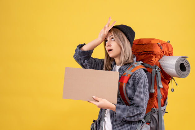 肖像疲惫的旅行妇女背着背包拿着纸板时尚背包女士