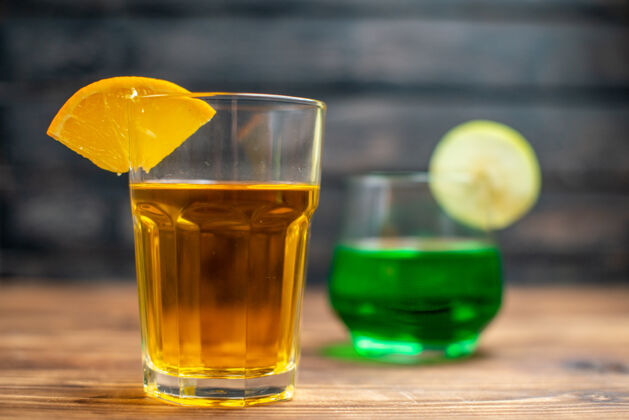 酒精正面视图新鲜水果汁橙汁和苹果饮料在棕色木制桌上的玻璃杯内饮用桌子里面玻璃杯