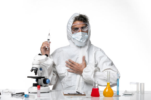 药品男医生穿着防护服 带着无菌口罩 拿着白色的注射器灭菌实验室外套视图