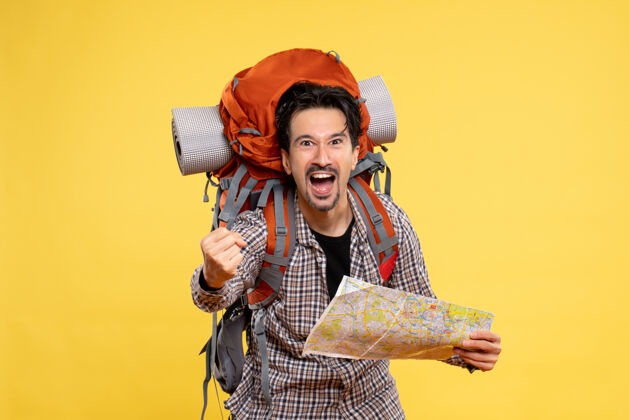 服装正面图：年轻男性带着背包徒步旅行 手持黄色背景地图 旅行航空自然公司校园色彩徒步旅行举行地图