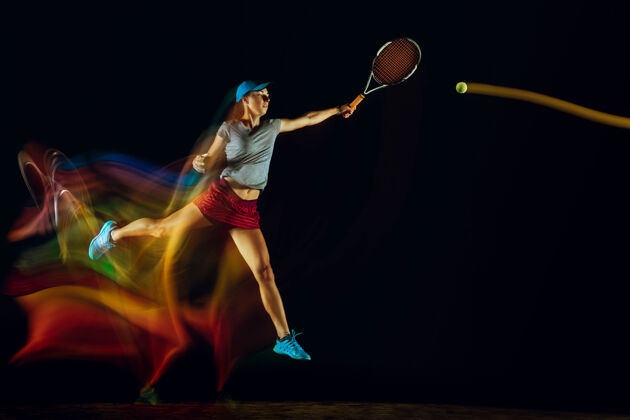 健康一个打网球的女人孤零零地站在黑色的墙壁上 混合着柔和的光线切割网球游戏
