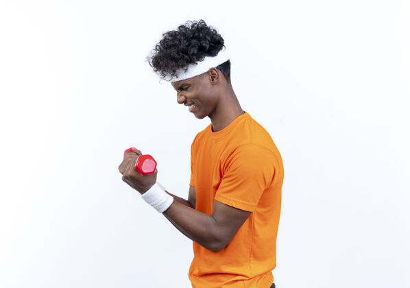 站立站在侧视图紧张的年轻非裔美国人运动男子戴着头带和腕带哑铃锻炼紧张头带穿着