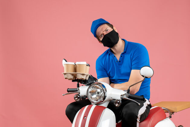 摩托车正面图男性信使坐在自行车上拿着咖啡杯在粉红色头盔举行快餐