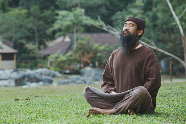 和平一个留着胡子的人正在绿草上冥想草放松胡须