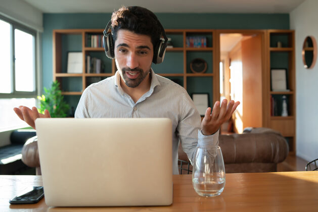 工作年轻人在家里用笔记本电脑进行工作视频通话的肖像家庭办公室概念新的正常生活方式工作场所通话会议