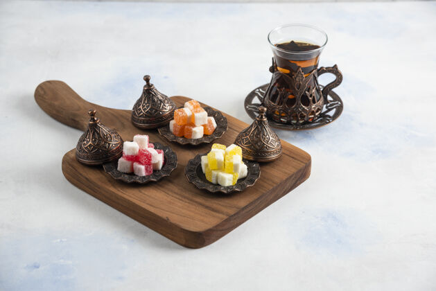 桌子新鲜热茶旁边的木板上放着五颜六色的糖果新鲜坚果火鸡