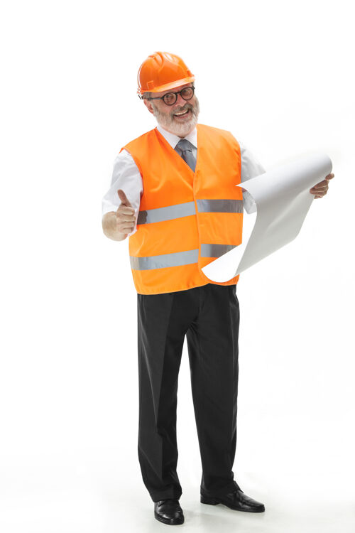男性穿着建筑背心和橙色头盔的建筑工人站在白色的工作室墙上专家专业人员工头