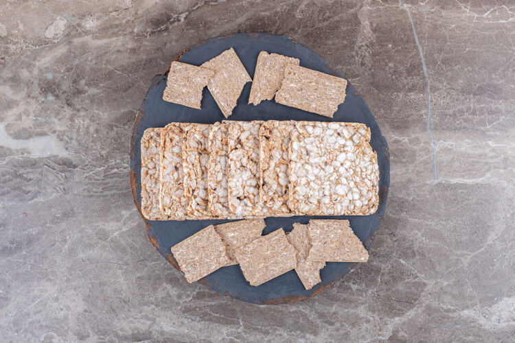 Puf在大理石表面的托盘里放着酥脆的面包和膨化的年糕风味健康面粉