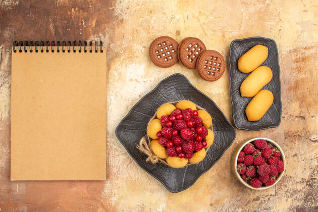 水果顶视图的礼物蛋糕和饼干在棕色盘子水果和笔记本上的混合颜色表午餐健康零食