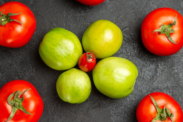 新鲜在黑暗的桌子上 红色和绿色的西红柿围着樱桃西红柿转多汁食品樱桃