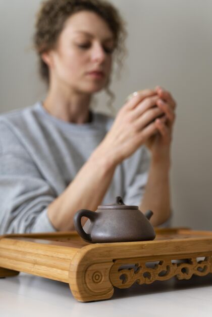 休闲一个卷发金发女人一边喝茶一边放松的侧视图宁静娱乐前视