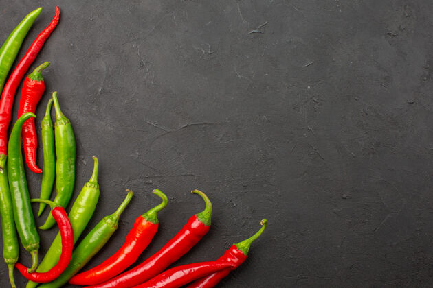 蔬菜顶视图红色和绿色的辣椒在左下角的黑表与自由空间辣椒有机胡椒