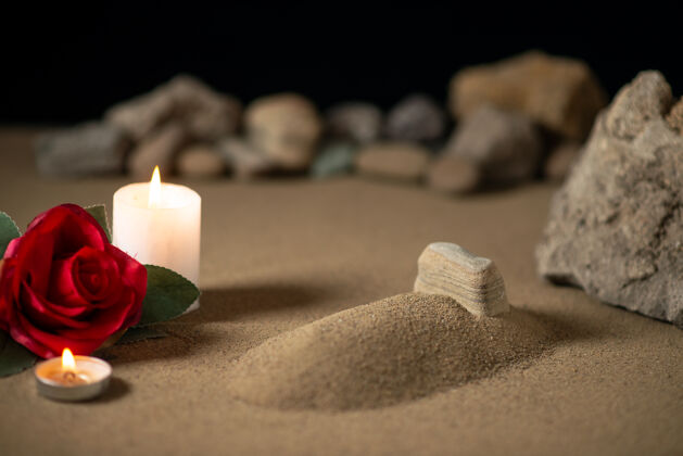 火在沙滩上用蜡烛和石头安葬月亮的小坟墓火焰战争石头
