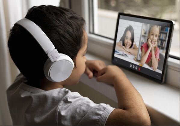 远程男孩戴着耳机和他的朋友在视频通话视频年轻视频聊天