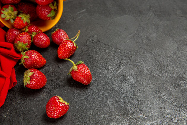 背景前视图新鲜的红色草莓在黑暗的背景下多汁正面浆果